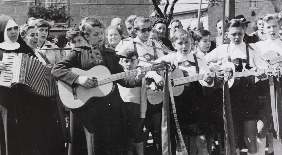 Kinder der Sing- und Spielgruppe, die bei einem Auftritt Gitarre und Akkordeon spielen.