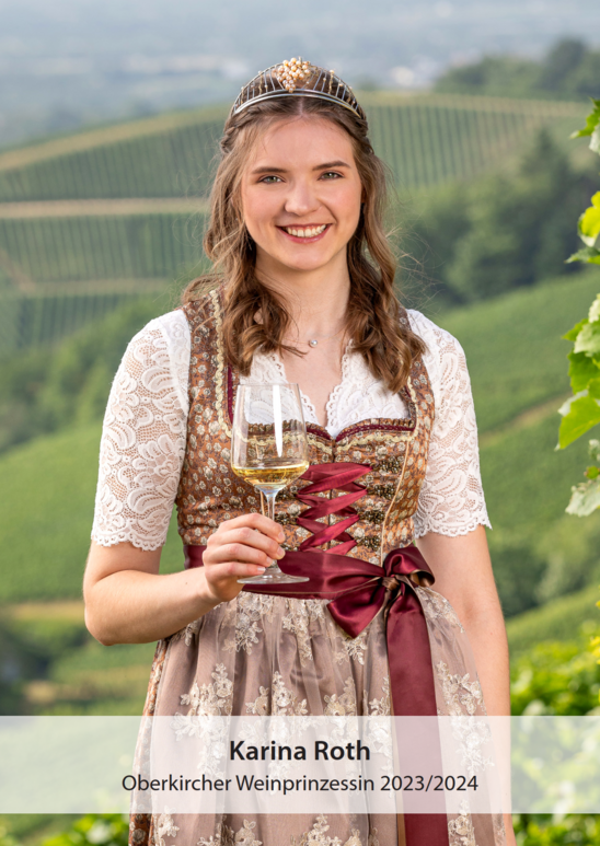 Junge Frau als Weinprinzessin mit einem Glas stehend in den Reben.